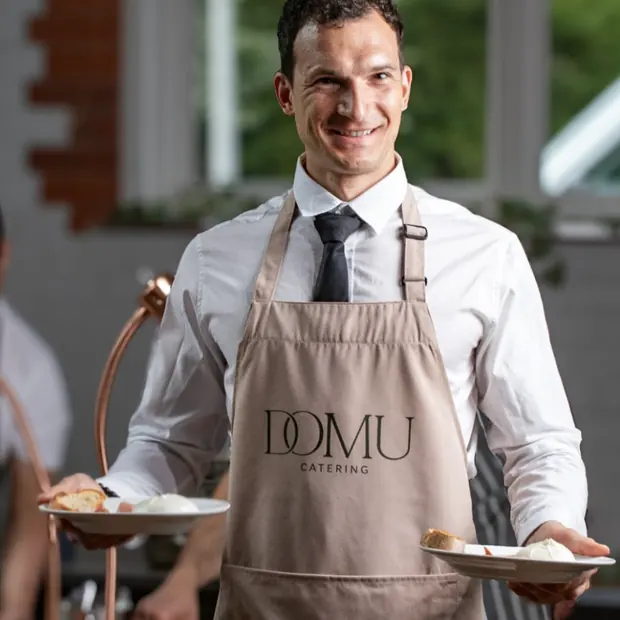 Domu front of house server carrying plated starters