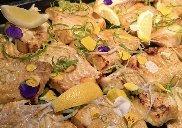 Marinated fish fillets finished with citrus and edible flowers